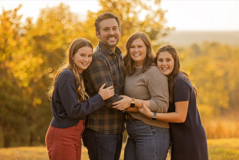 Jonathan Pyle with his family in a field at golden hour
